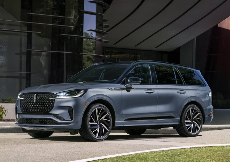 A gray 2025 Lincoln Aviator® SUV is parked outside a modern building showcasing the driver’s side of the vehicle. | North Park Lincoln in San Antonio TX
