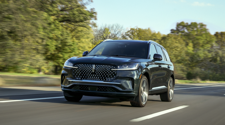 A 2025 Lincoln Black Label Aviator® SUV is being driven down a road lined with trees. | North Park Lincoln in San Antonio TX