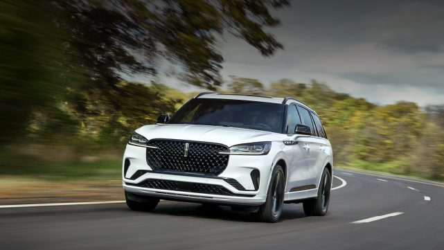 A white 2025 Lincoln Aviator® SUV is being driven down a road lined with trees. | North Park Lincoln in San Antonio TX