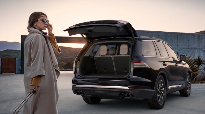 A woman approaches a 2026 Lincoln Aviator® SUV with its rear liftgate open. | North Park Lincoln in San Antonio TX